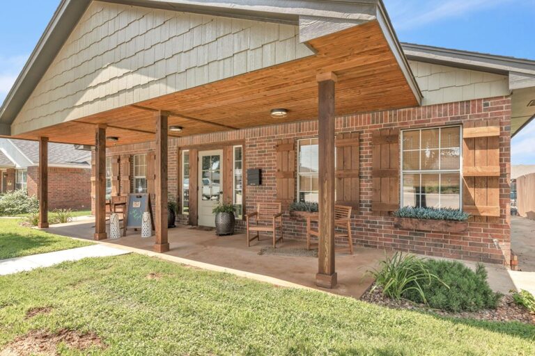 Covered front porch of the clubhouse with wood beams and seating