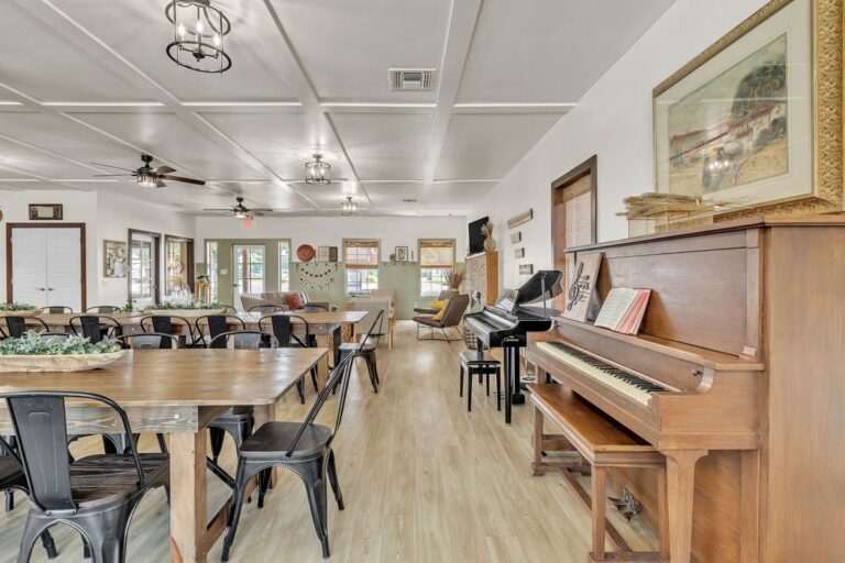 Clubhouse dining tables with a piano in the background