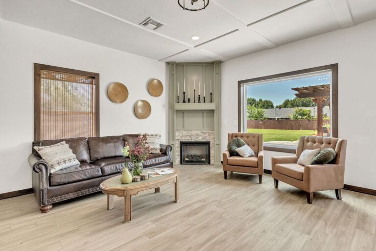 Clubhouse sitting room with a leather sofa, fireplace and large window