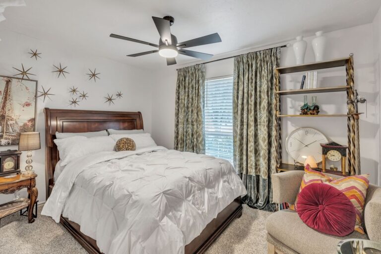 Cottage bedroom with a ceiling fan and a large window
