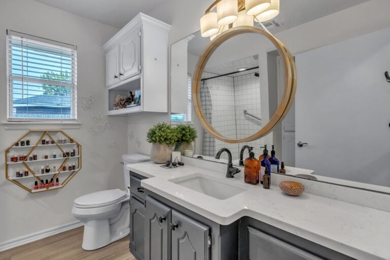 Cottage bathroom with a vanity, round mirror and updated finishes